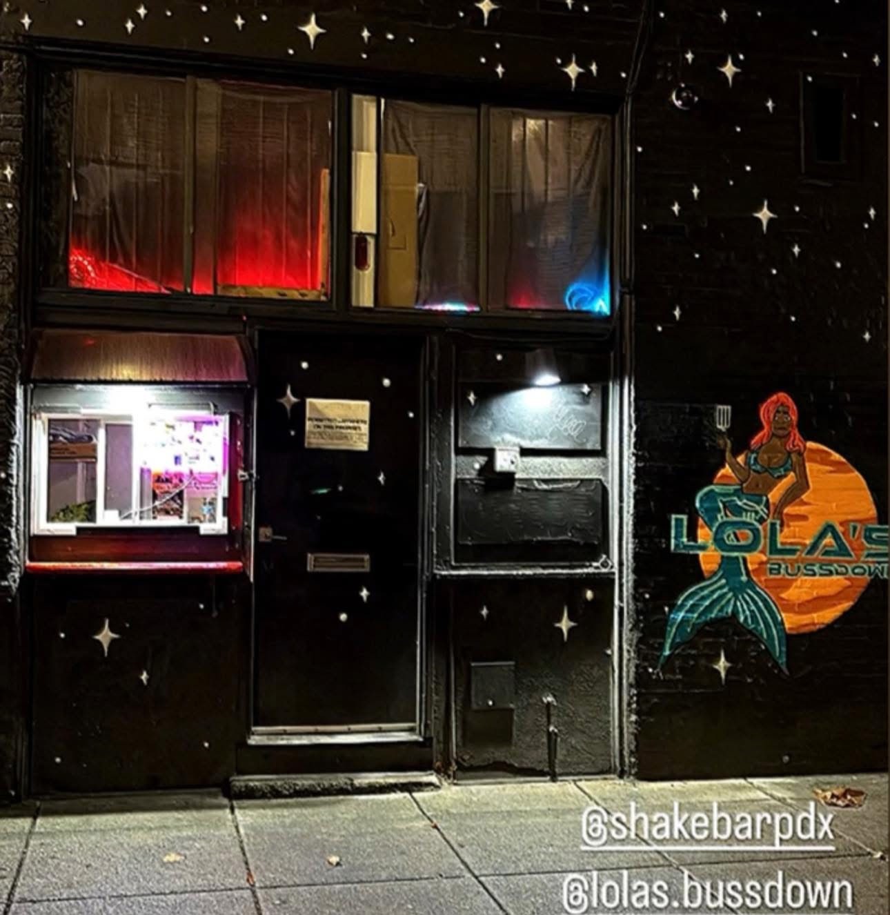 Lola’s Bussdown’s Chinatown storefront at night, with its serving window and mermaid mural